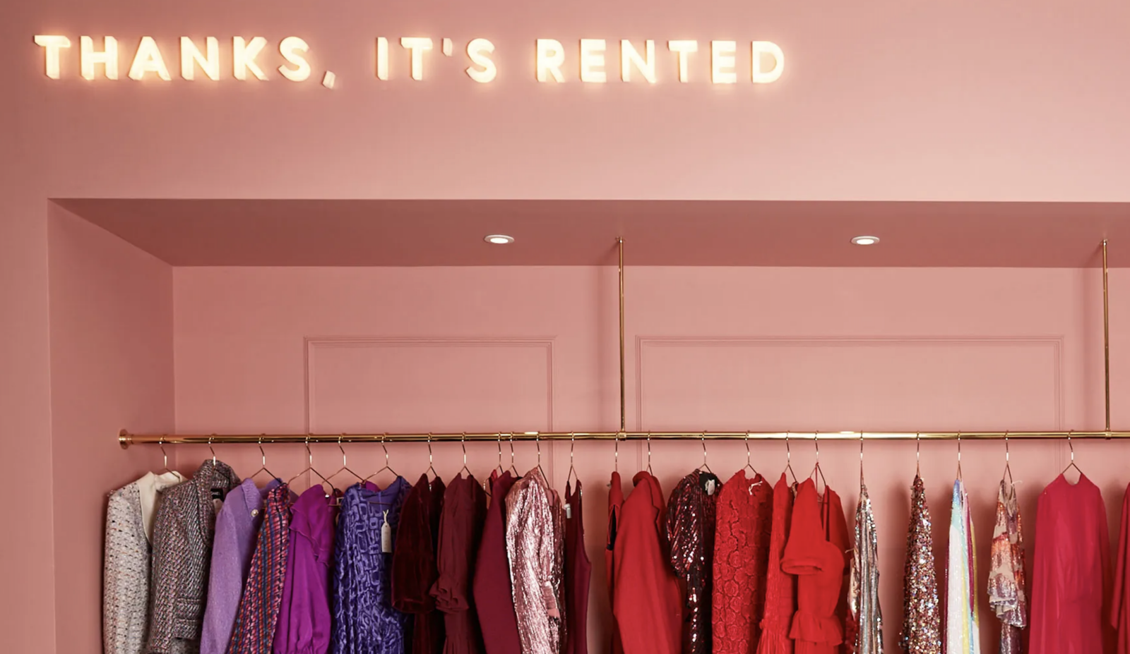 Clothing on a rack under a sign that says, "Thanks, It's Rented."